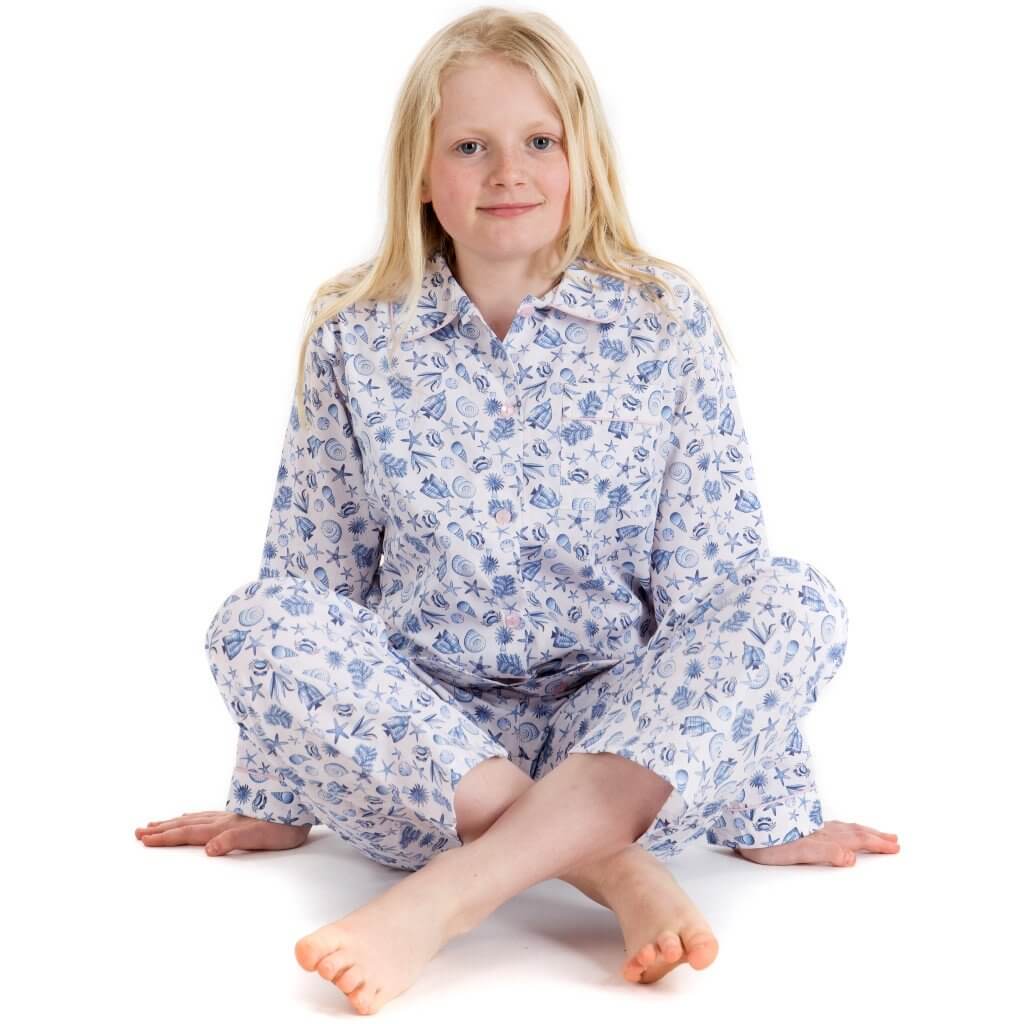 Kitty, seated, wearing fine cotton seashell print pyjamas for girls