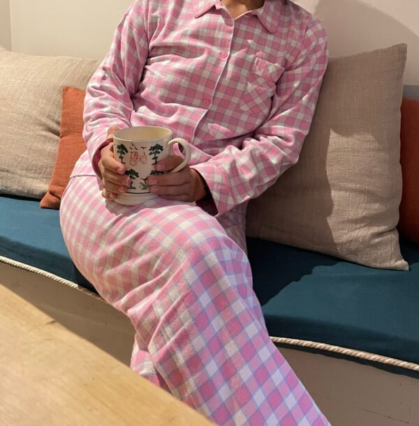 Pink check pyjamas for women worn by Imo, sitting